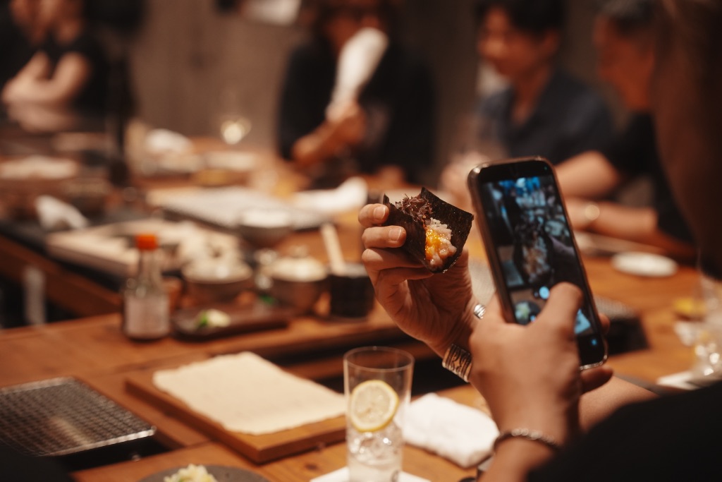 牡蠣料理を撮影するゲストと提供される様子